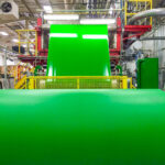 A bright green coating from Greif being applied to roll stock paper