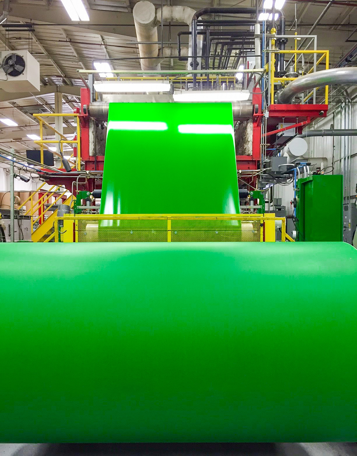 A bright green coating from Greif being applied to roll stock paper