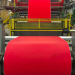A bright red coating from Greif being applied to roll stock paper