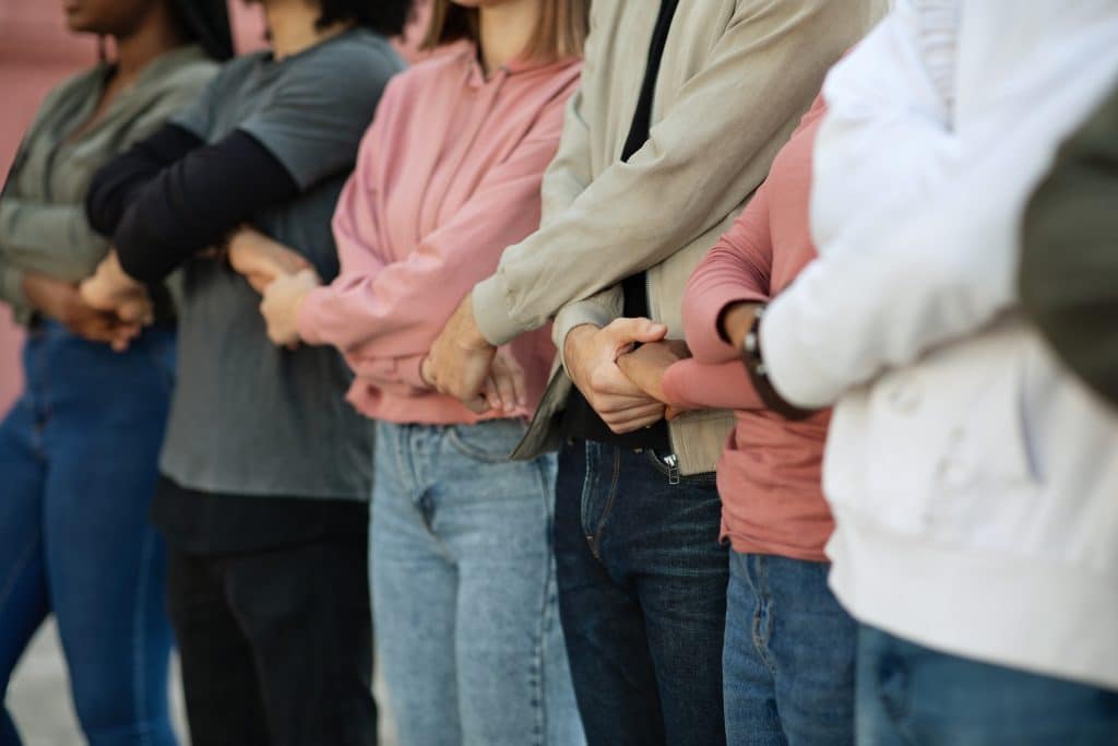 Group of protestors standing together holding hands in picket