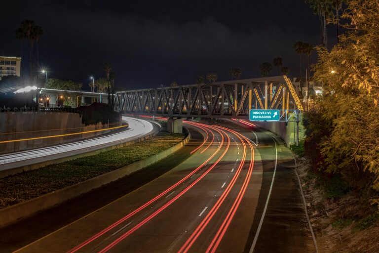 A long exposure photograph shows vehicle lights as long lines against a night scene on the 101 freeway